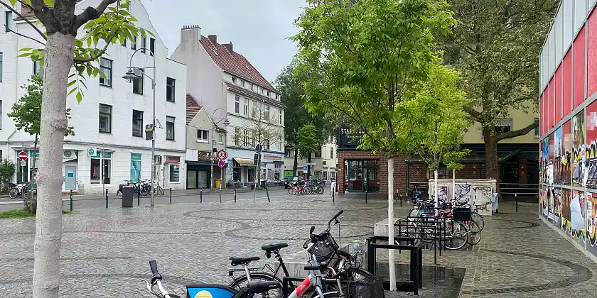 Delmemarkt mit Bäumen, Fahrradbügeln und Pflasterung