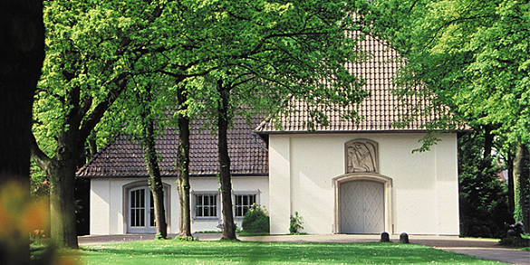 Hecke mit großer Marmorvase