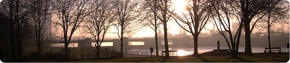 Blick auf Fluss mit Bank und Sonnenaufgang