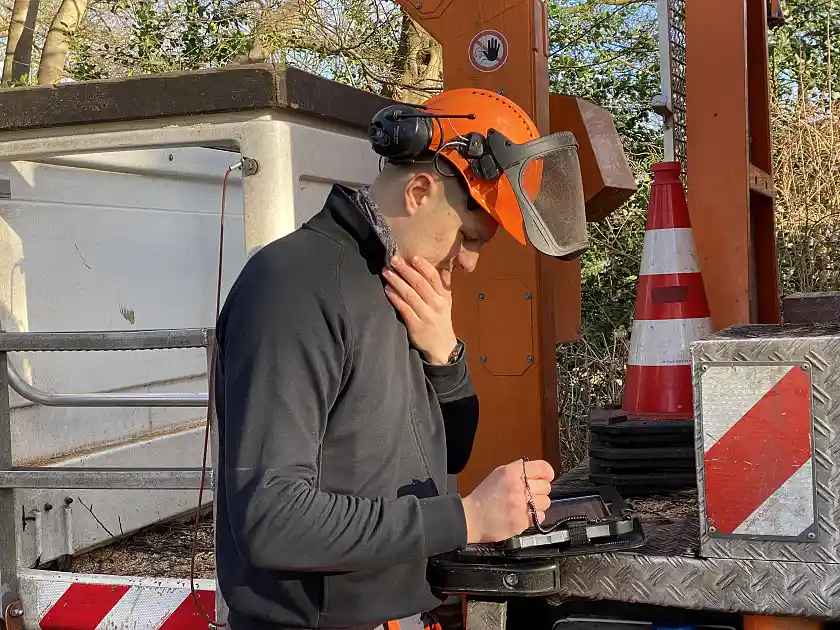 Mitarbeiter blickt pr&uuml;fend auf ein kleines, Tablet-&auml;hnliches Ger&auml;t