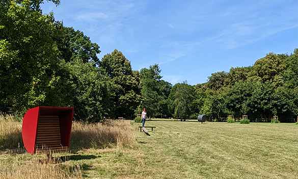 Rote Bank die auf einer Wiese steht.
