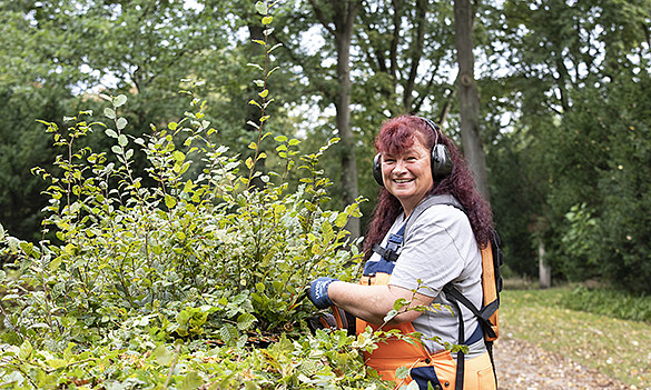 Gärtnerin schneidet Hecke 